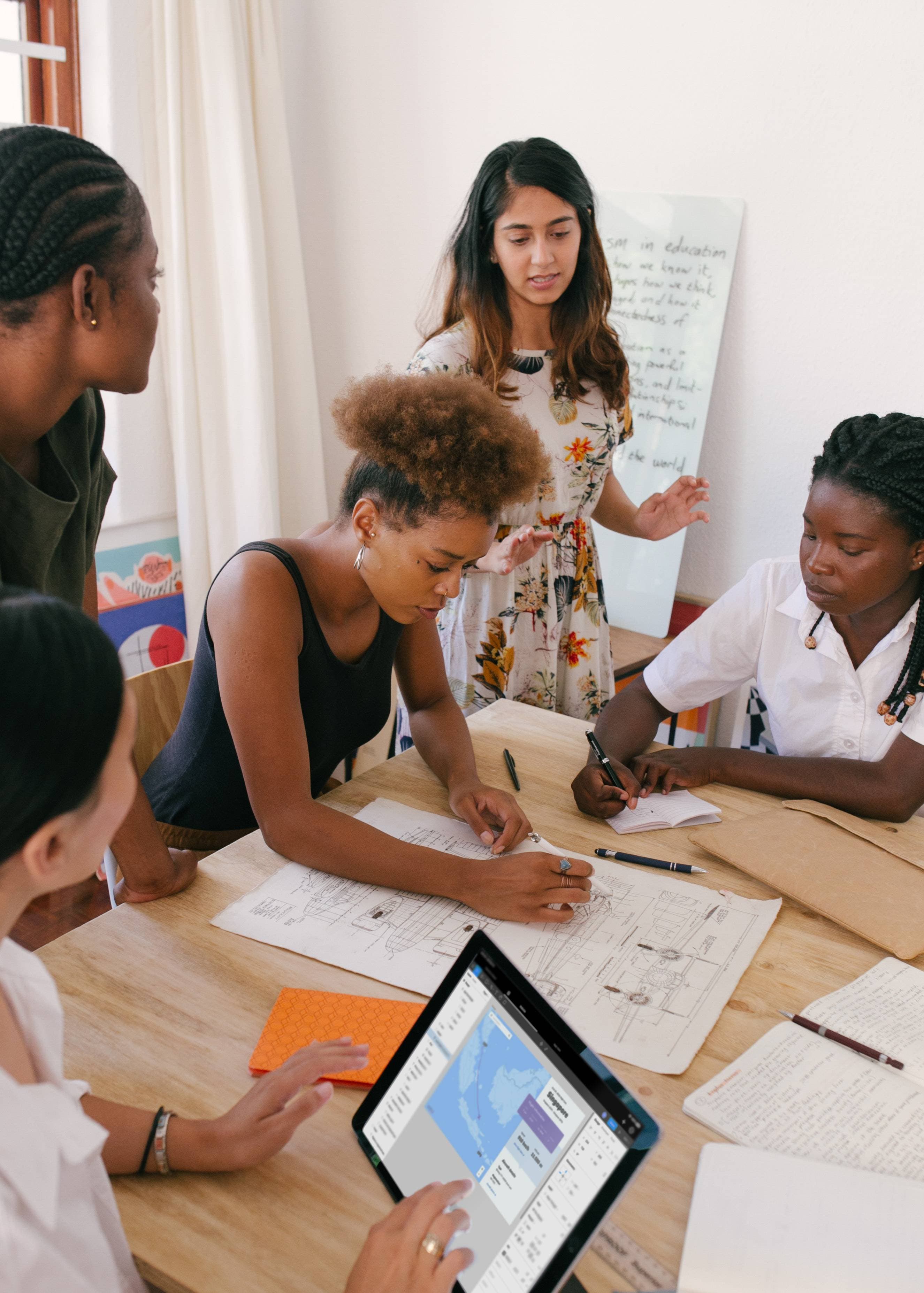 A problem solving workshop where two people are looking at Post-it notes on a whiteboard to understand a problem.